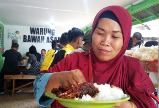 Salah seorang pengunjung tengah menikmati maskan khas Banjar, Nasi MAsak Habang Iwak Haruan. Poto : R a m a