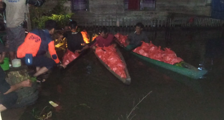 Warga Gunakan Perahu Untuk Angkut Bantuan PT AGM
